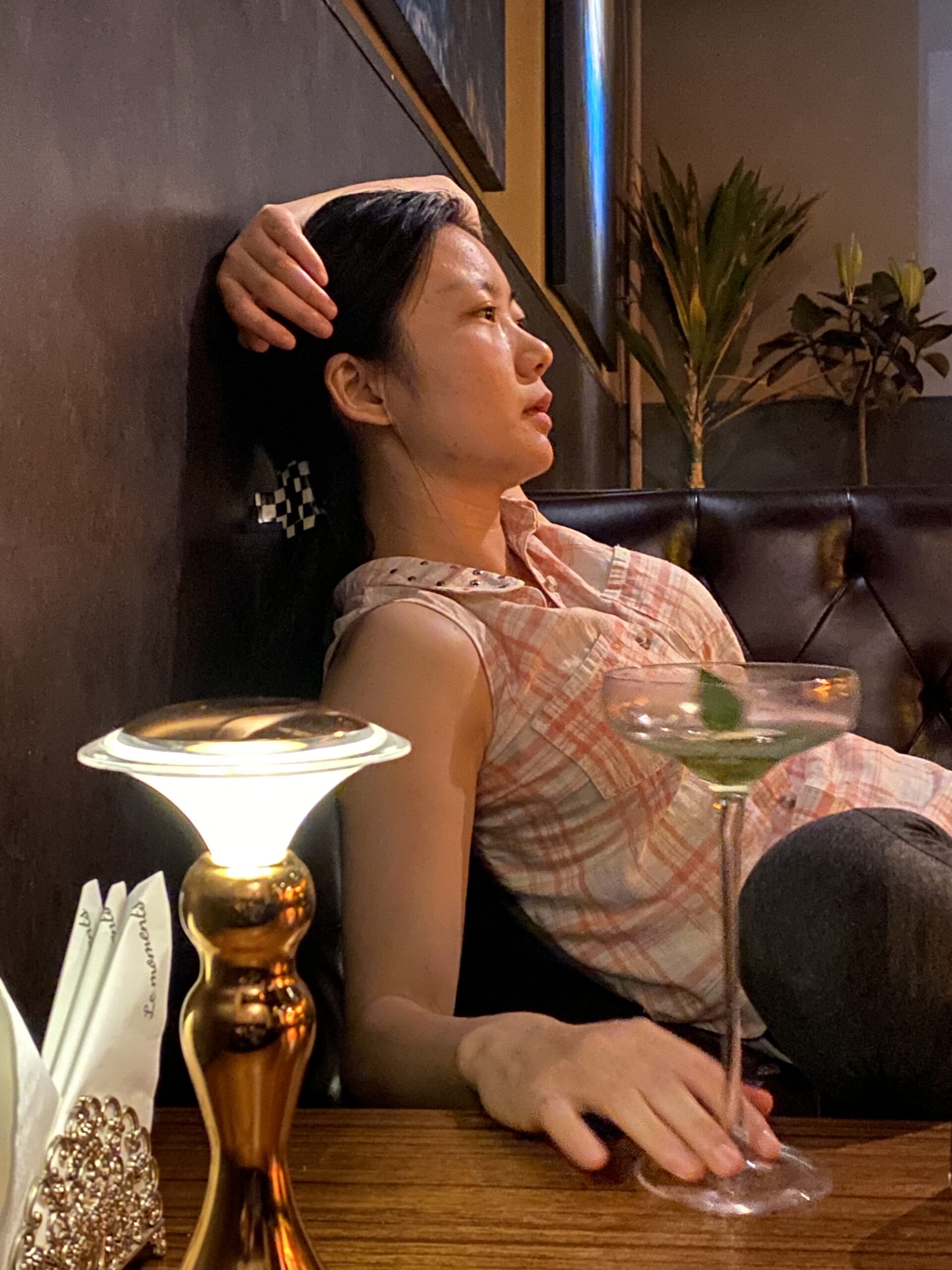 Thai woman relaxing with a green cocktail in a cozy Ubon bar