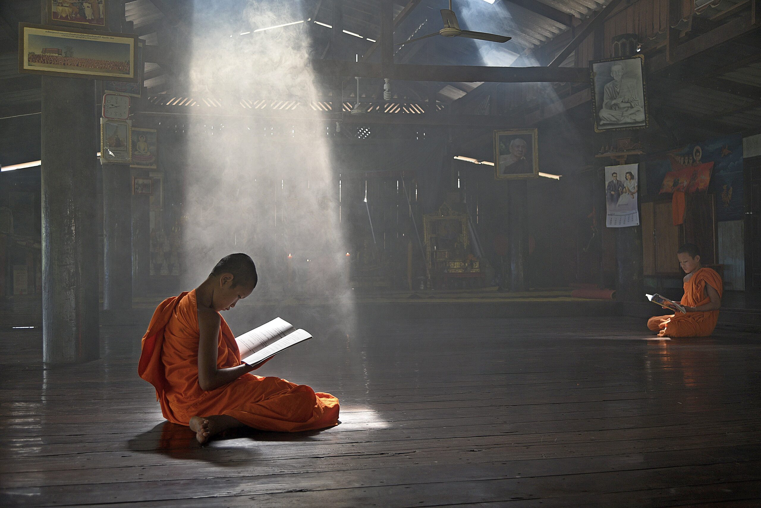 Young novice Thai monk meditating in a sunlit temple